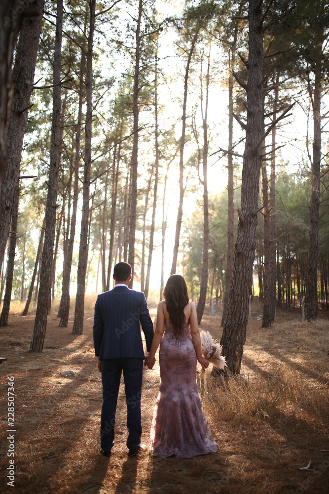 Lovely couple was walking and posing in the woods with happiness Lovely couple was walking and posing in the woods with happiness