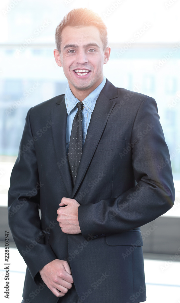portrait in full growth. confident businessman standing in the spacious lobby