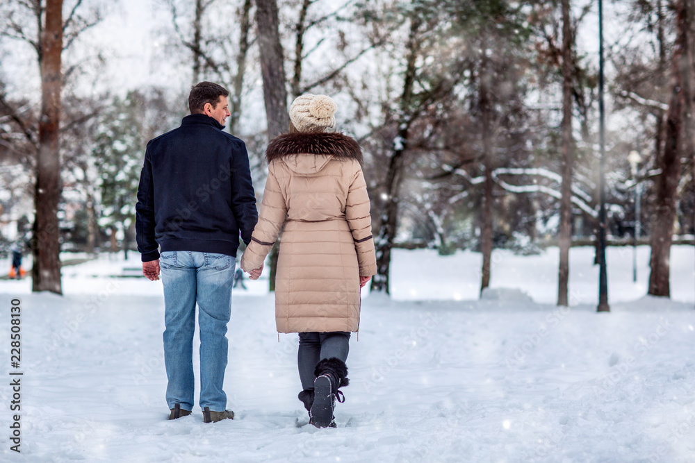 .young couple having a walk in winter park.