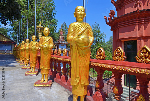 Golden statues stand in a row at a Buddhist temple in Sihanoukville  Cambodia.