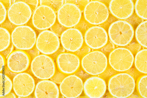 A slices of fresh juicy yellow lemons. Texture background, pattern.