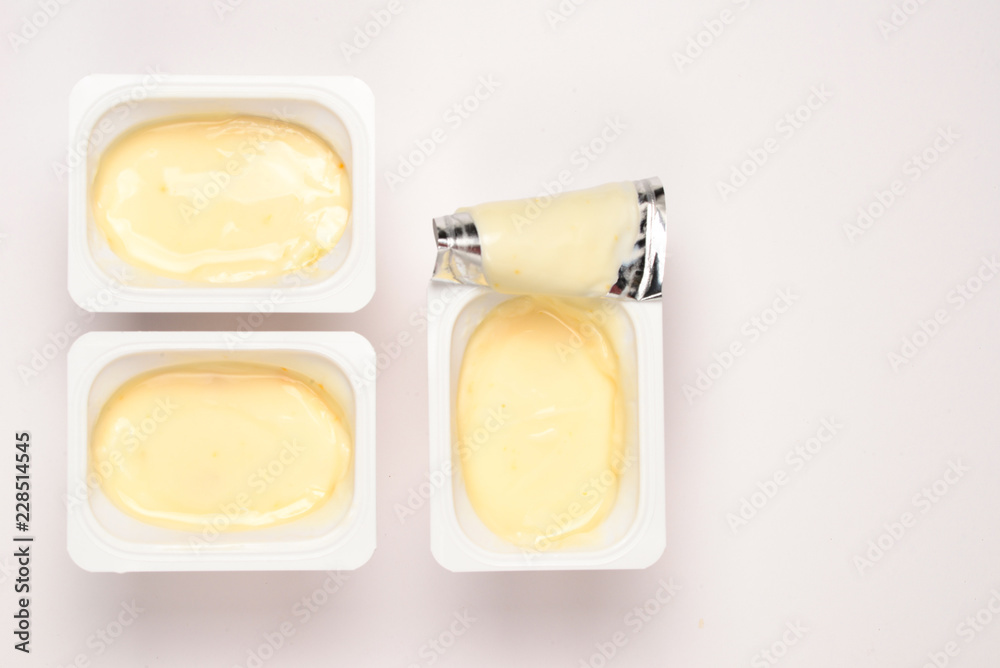 Plastic cup with tasty yogurt isolated on white. Top view. Space for text or design.