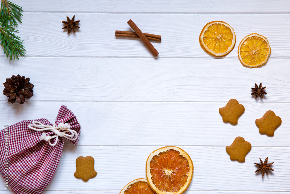 Christmas  holidays celebration background, red sicilian dried orange, pinecones, driend oranges, anise stars and ginger cookies on white wooden rustic table background, top view. Copy space.