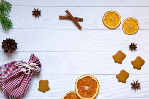 Christmas  holidays celebration background, red sicilian dried orange, pinecones, driend oranges, anise stars and ginger cookies on white wooden rustic table background, top view. Copy space. photo