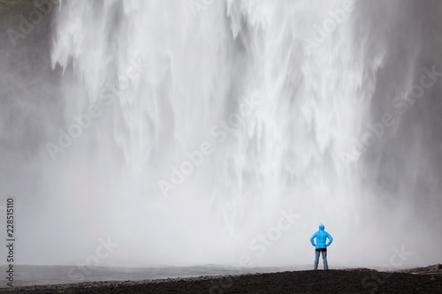 Skogafoss waterfall with a hiker, Skogar, South Iceland, Iceland, Europe
