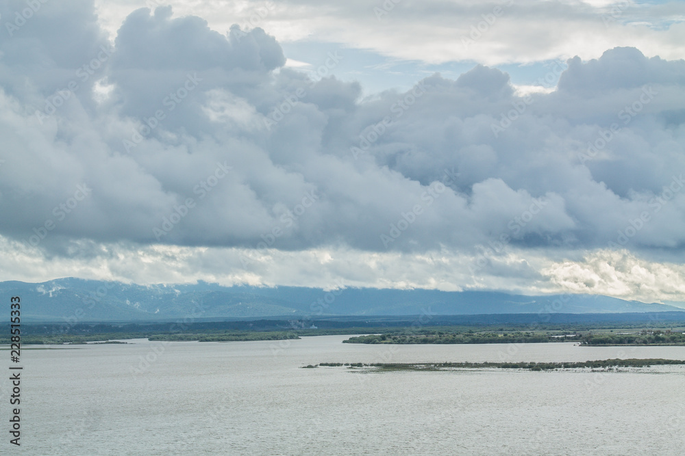 Obraz premium Landscape of water reservoir and big dark clouds in rainy season. Ecology, natural environment and water irrigation management concept.