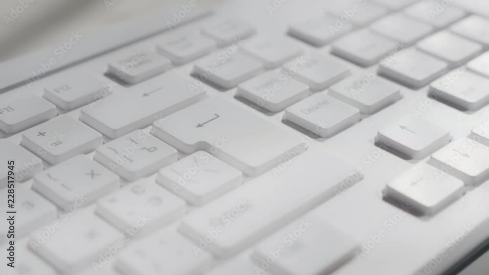 Pressing the enter key on a computer keyboard. Macro footage.