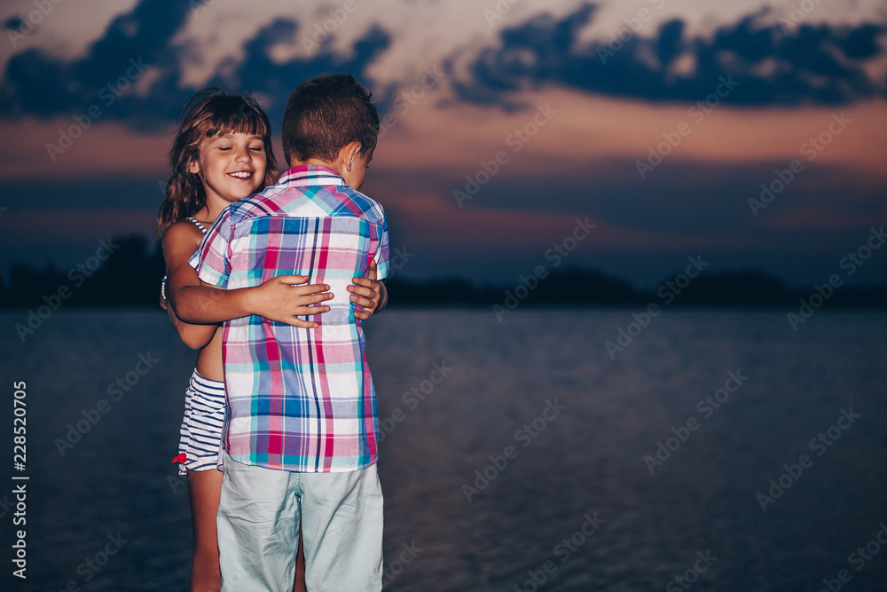 Little boy and a girl while standing and hugging Little boy and a girl while standing and hugging