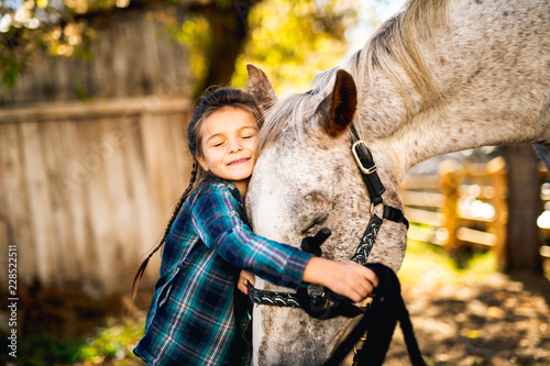 in a beautiful Autumn season of a young girl and horse