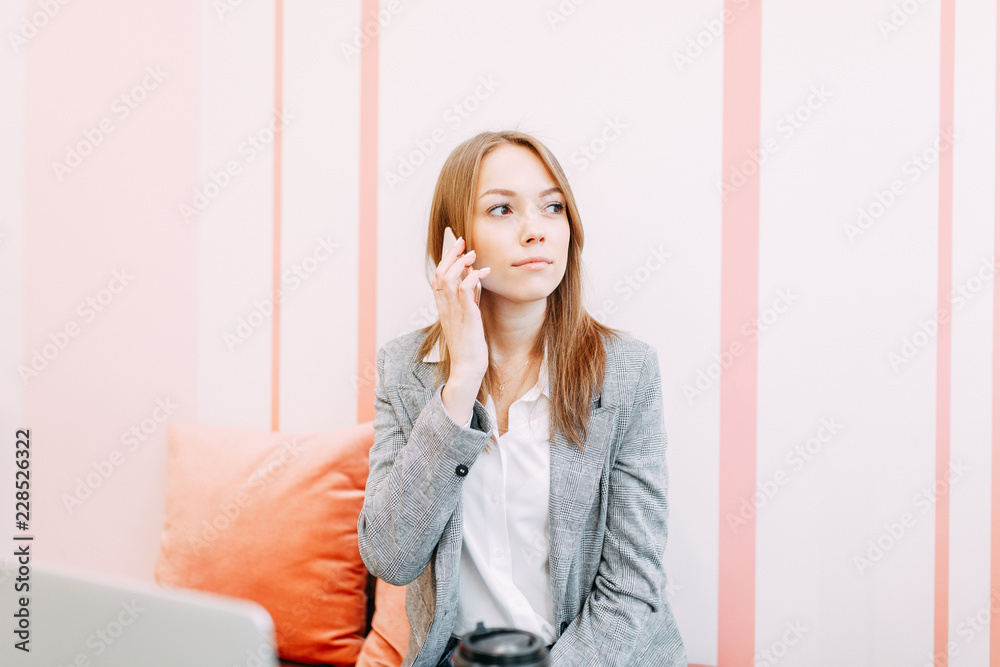 Girl blogger with coffee sitting in a coffee shop and working. Laptop and phone in hand. Business style in clothes. Girl blogger with coffee sitting in a coffee shop and working. Laptop and phone in hand. Business style in clothes.