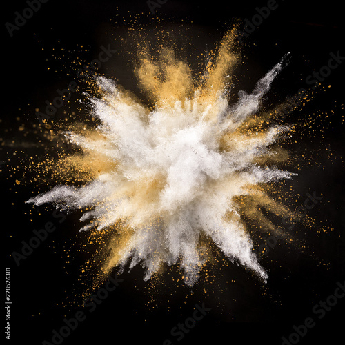 Silver and gold powder explosion on black background.