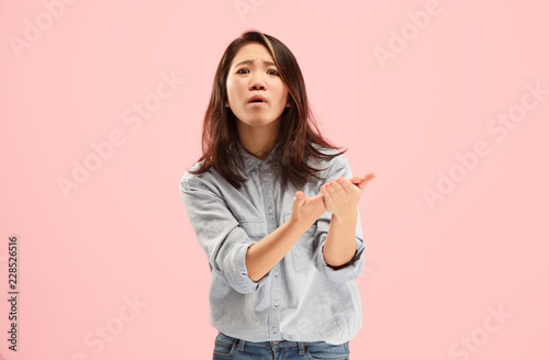 Argue, arguing concept. Beautiful female half-length portrait isolated on pink studio backgroud. Young emotional surprised woman looking at camera.Human emotions, facial expression concept. Front view