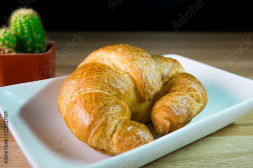 Tasty buttery croissants on old wooden table.
