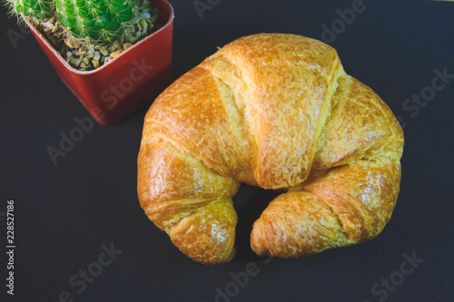 Tasty buttery croissants on old wooden table.