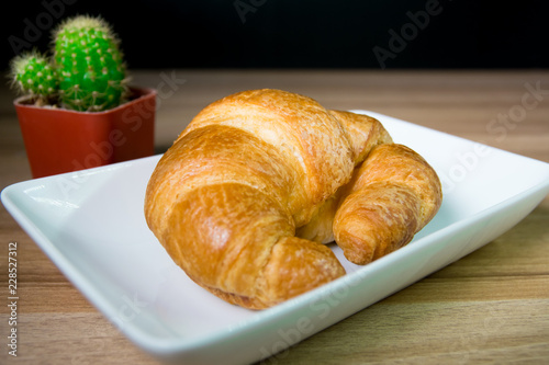 Tasty buttery croissants on old wooden table.