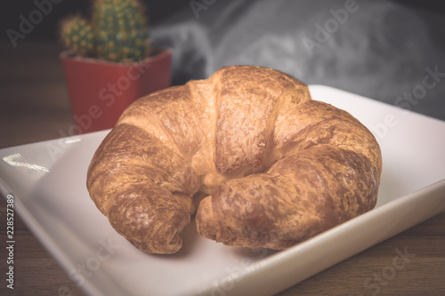 Tasty buttery croissants on old wooden table.