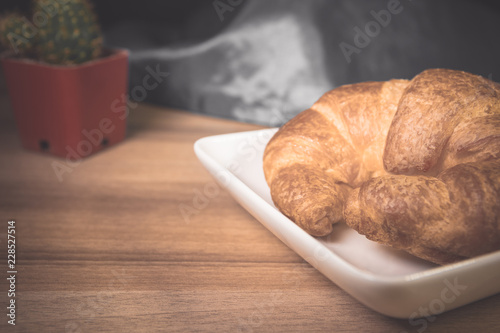 Tasty buttery croissants on old wooden table.