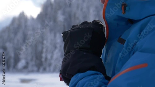 Slow motion - Adult male zipping his winter jacket and looking away