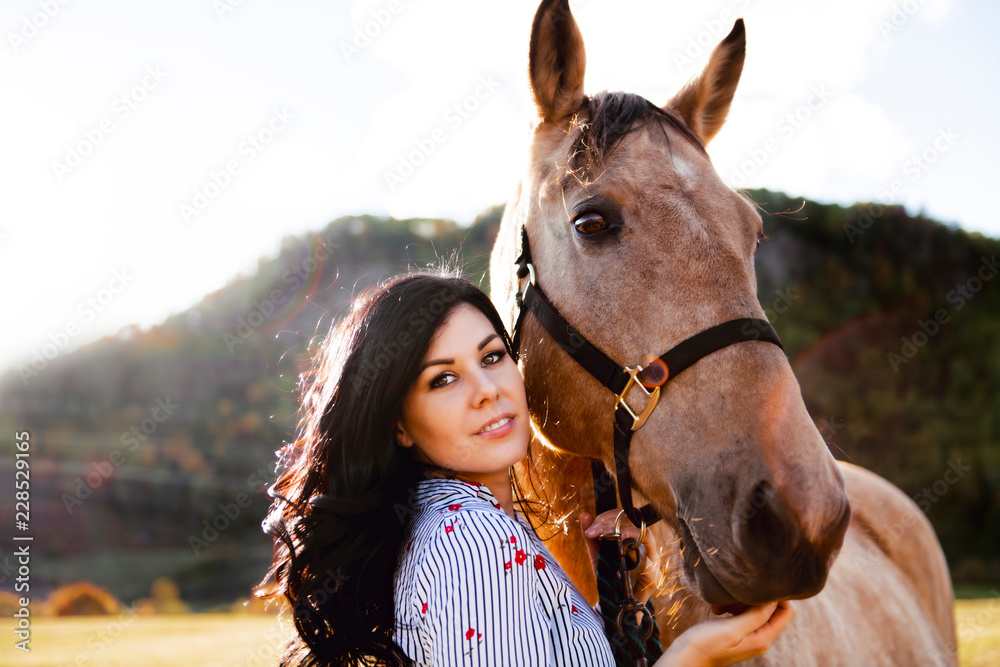 Obraz premium A Woman with her horse at sunset, autumn outdoors scene