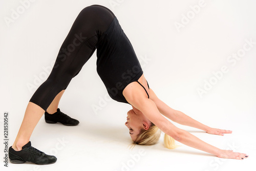 Studio photo of a beautiful blonde girl doing fitness stretching exercises on a white background. photo