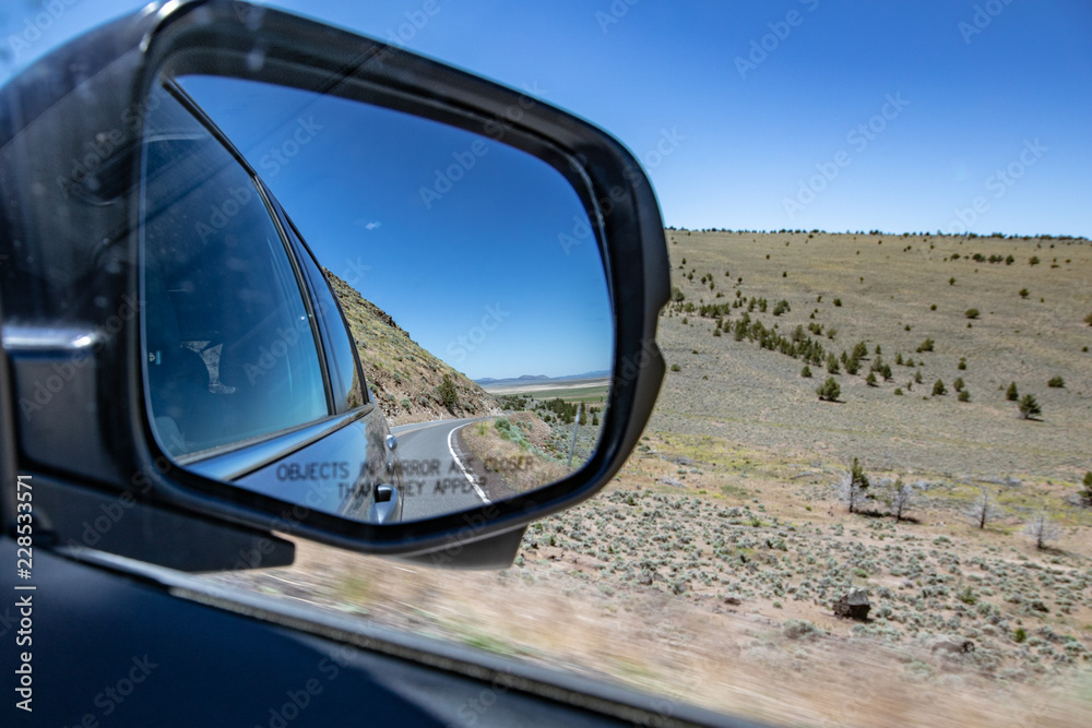 Asphalt road in car side mirror