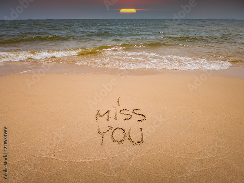 Font hand writing on sand of i miss you on the beach