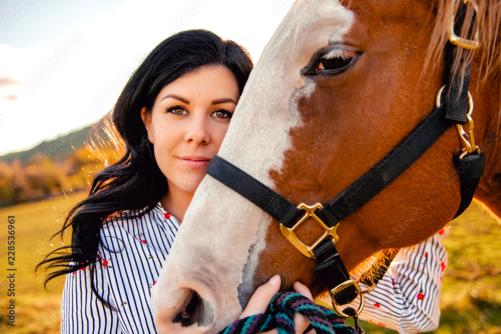 Obraz premium A Woman with her horse at sunset, autumn outdoors scene