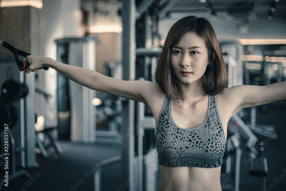 Woman with sport clothing exercise in the fitness gym. Modern women healthy lifestyle. 
