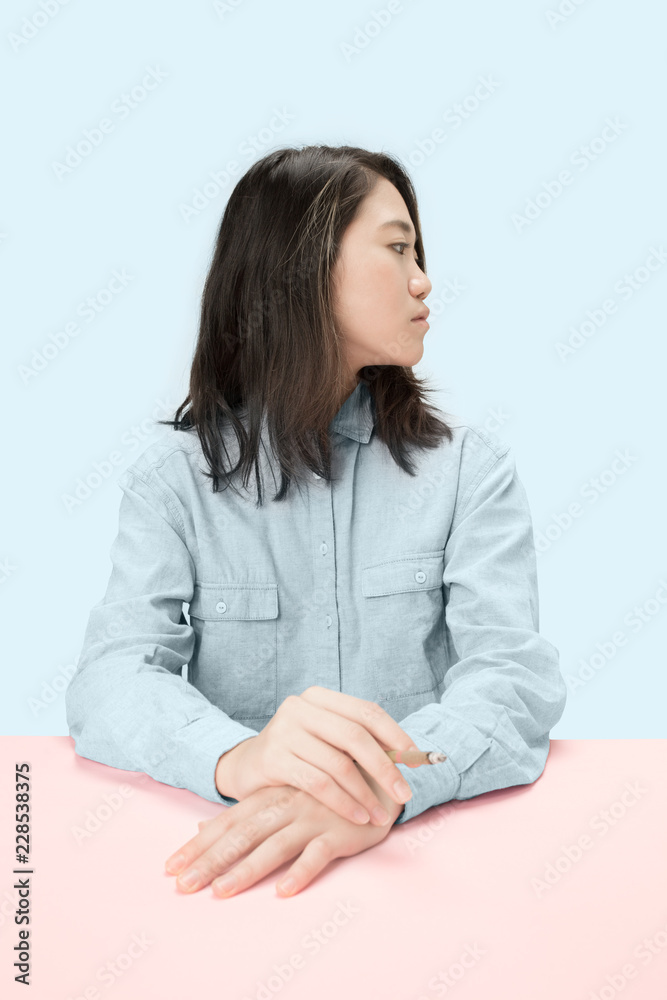 Handsome young korean women smoking cigar while sitting at table at studio. Trendy colors Handsome young korean women smoking cigar while sitting at table at studio. Trendy colors