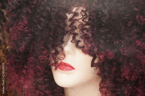 closeup of woman face of mannequin with afro wig in fashion store showroom