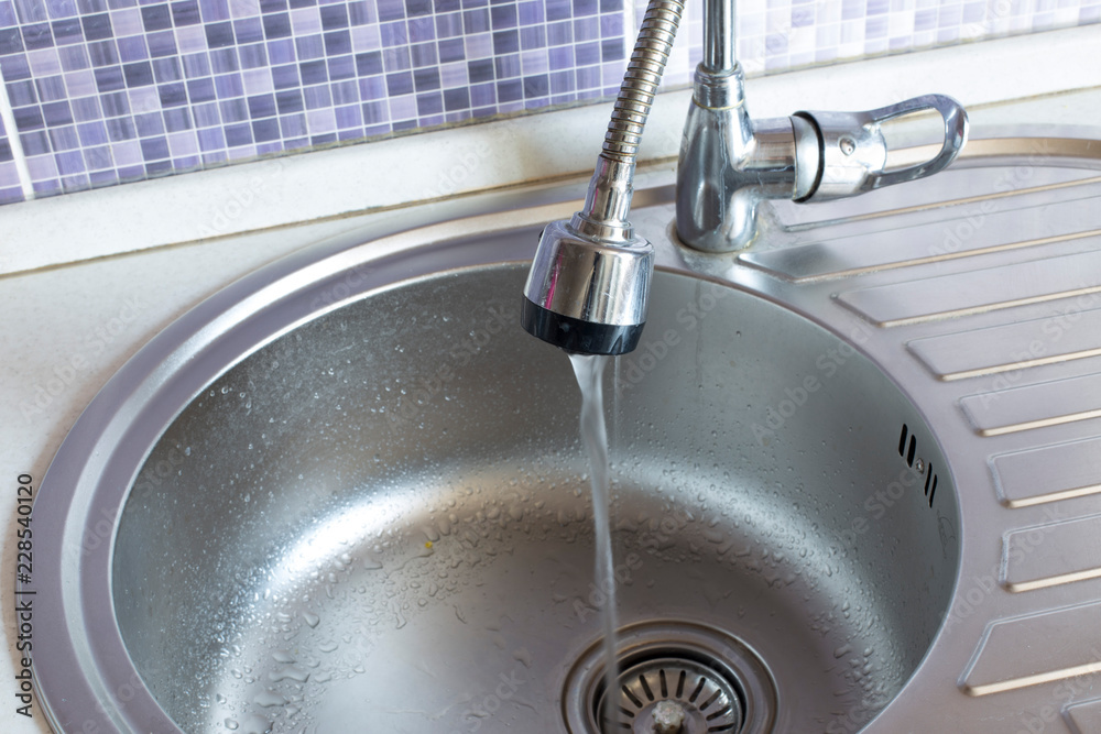 Water flowing from the faucet to the washbasin Water flowing from the faucet to the washbasin