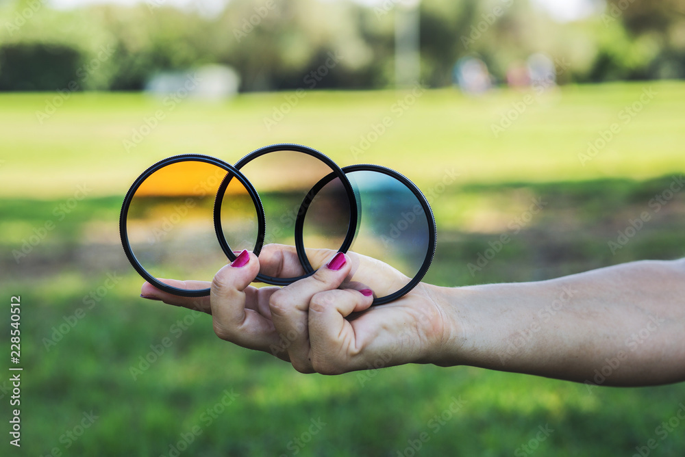 Hand holding three gradient filters.