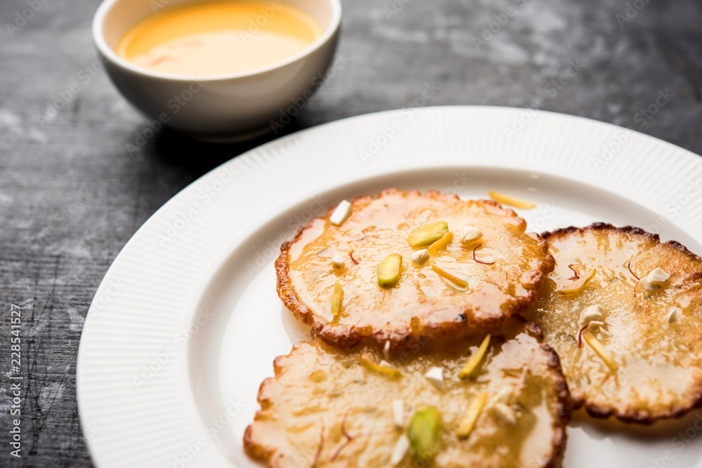 Malpua sweet - Traditional Indian dessert or pancake for festivals, served in plate with rabri/rabdi . selective focus Malpua sweet - Traditional Indian dessert or pancake for festivals, served in plate with rabri/rabdi . selective focus