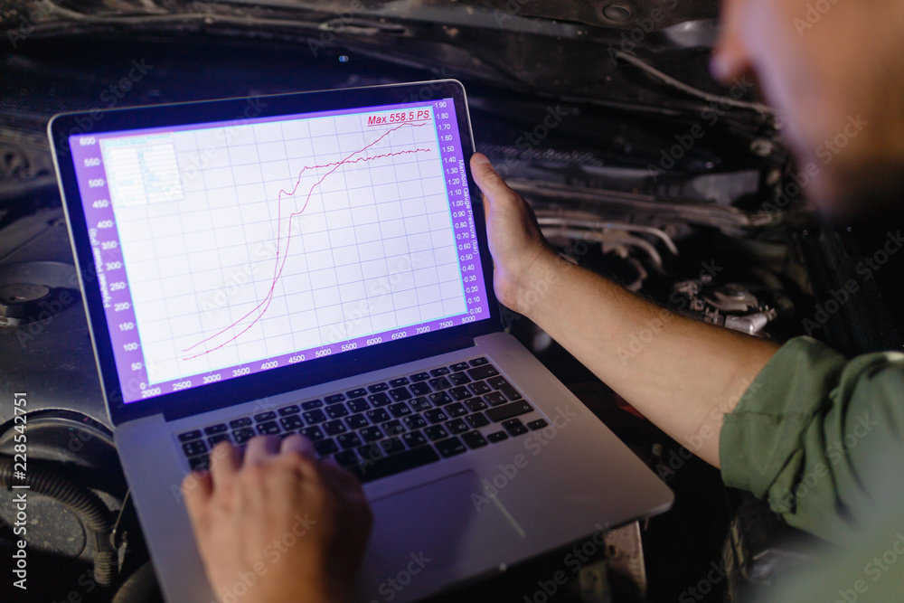 Closeup hands of mechanic with the help of diagnostic machines is ready