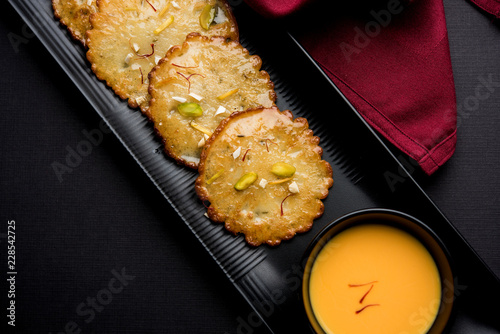 Malpua sweet - Traditional Indian dessert or pancake for festivals, served in plate with rabri/rabdi . selective focus photo