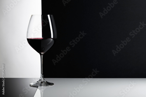 Glass of red wine on a reflexive background.