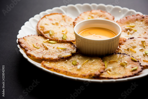 Malpua sweet - Traditional Indian dessert or pancake for festivals, served in plate with rabri/rabdi . selective focus photo