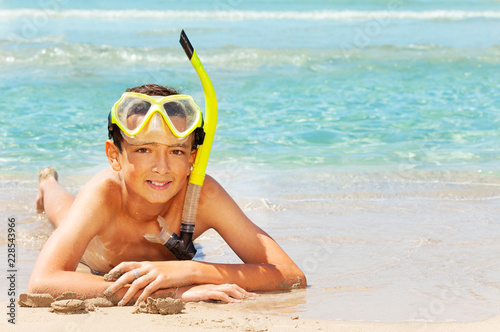 Young diver resting on sandy beach in summer
