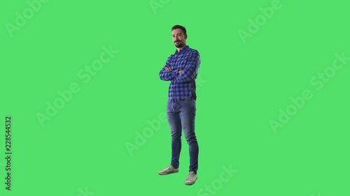 Confident successful happy young casual bearded man standing and crossing arms. Full body isolated on green screen background. 