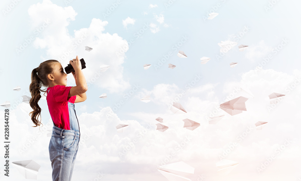 Concept of careless happy childhood with girl looking in binoculars Concept of careless happy childhood with girl looking in binoculars