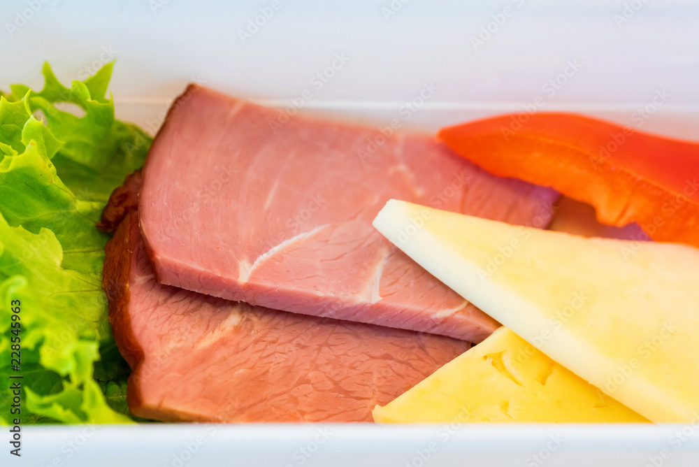 Plastic bowl with sliced food for airplane meal close Plastic bowl with sliced food for airplane meal close