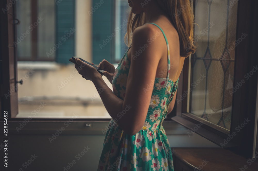 Obraz premium Young woman using smart phone at home