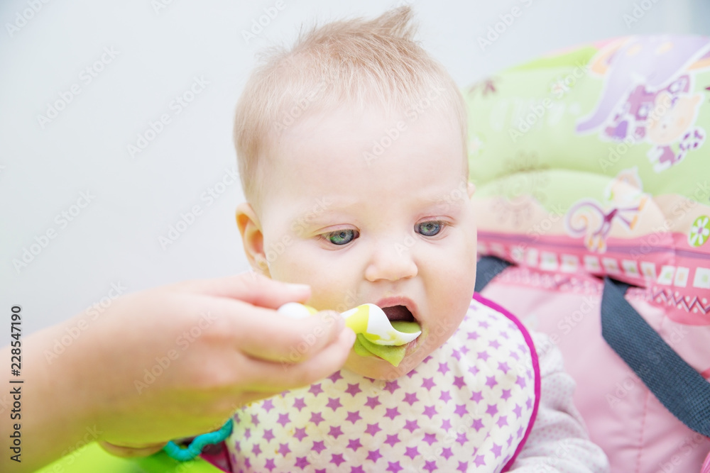 The baby learns to eat from a spoon. The first lure of the baby. The baby learns to eat from a spoon. The first lure of the baby.