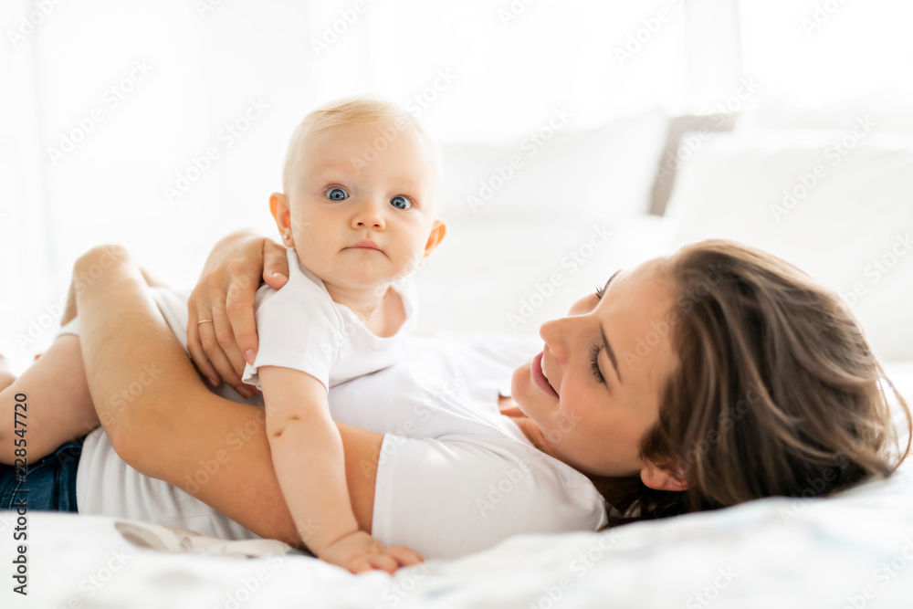 mother with baby on bed having good time mother with baby on bed having good time
