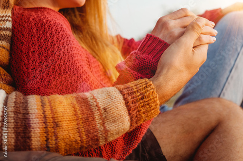 Man and woman holding hands with rings and hugging in sunrise, married couple