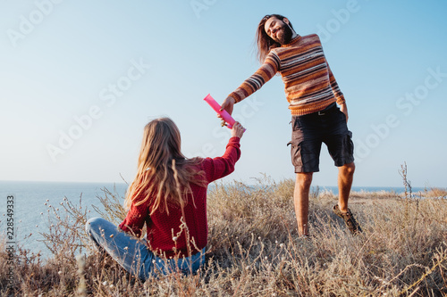 Hipster woman and man friends passing each other water bong outdoors