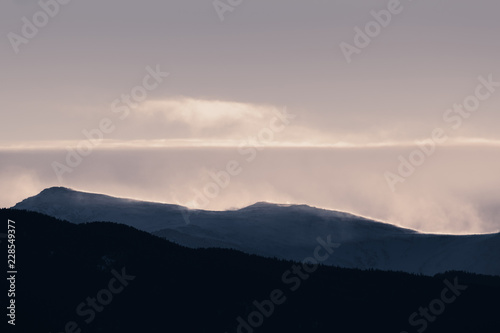 Fototapeta Naklejka Na Ścianę i Meble -  Dramatic winter storm blows over a cold barren landscape at sunset