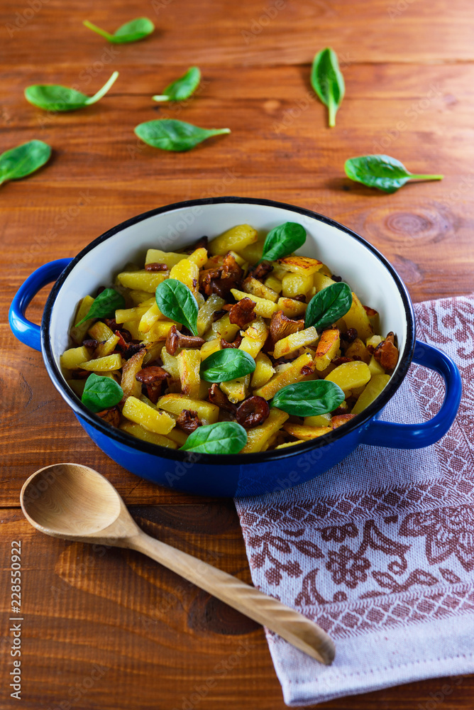 Fried potatoes with chanterelle mushrooms on a wooden table. Traditional Russian dish Fried potatoes with chanterelle mushrooms on a wooden table. Traditional Russian dish
