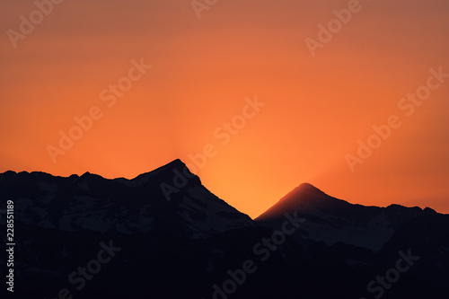 Dramatic sun rays as the sun sets behind Heaven s Peak and Livingston Range  in Glacier National Park  Montana