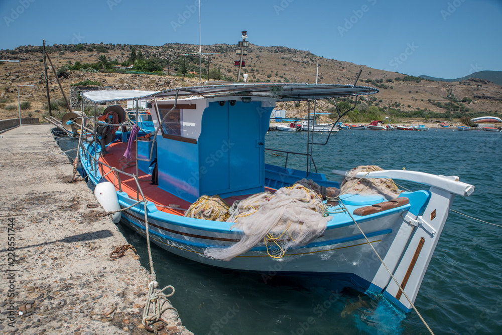 Greek fishing boat tied up at a cement pier